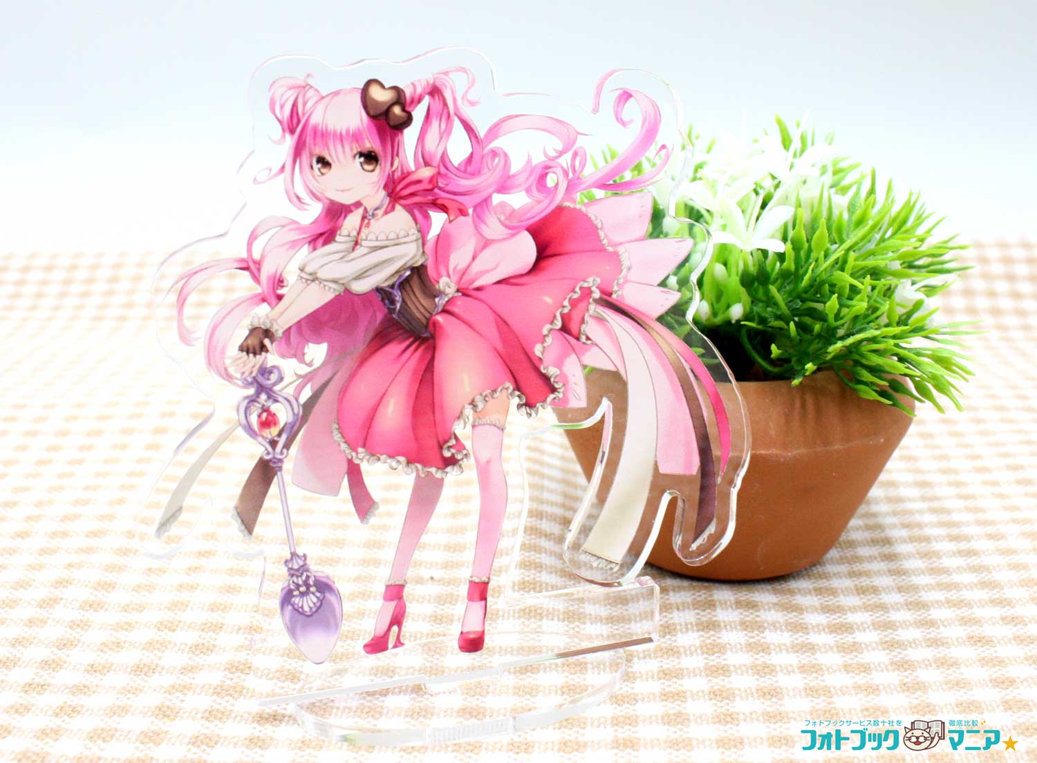 髪やリボンが広がったイラストのアクリルスタンドを、鉢植えの横に飾った作例